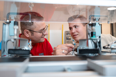 Two employees take a closer look at a system